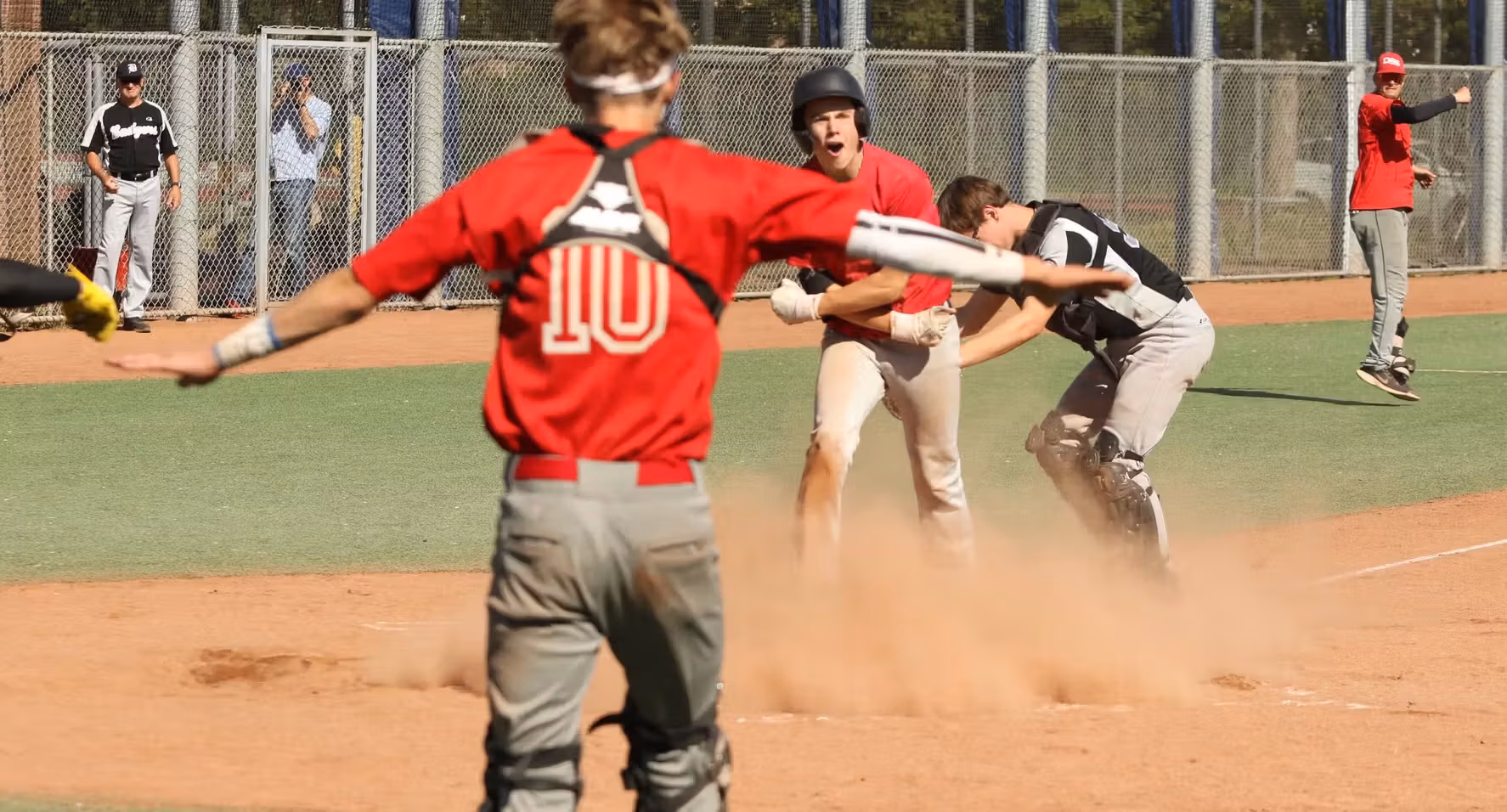DSS Haarlem honkbalspeler viert een gescoorde run bij de thuisplaat.